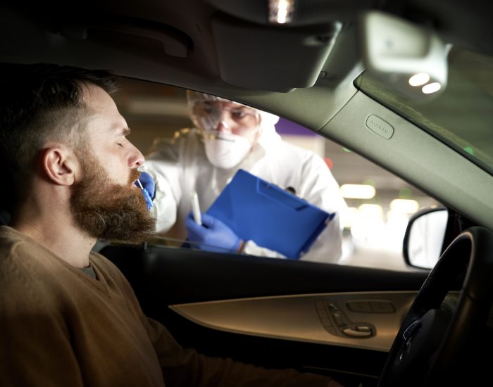 Medical worker performing drive-thru COVID-19 test