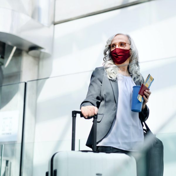 Senior woman in airport lounge, coronavirus, travel and new normal